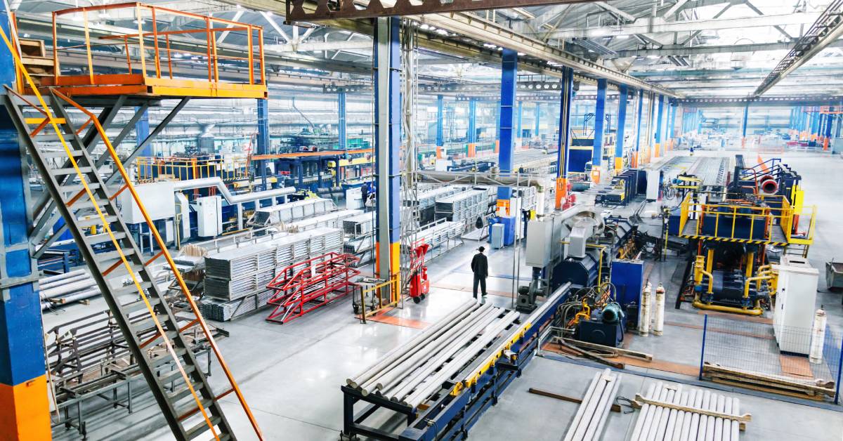 A wide shot of a manufacturing facility, with many different materials and pieces of equipment spread throughout the shot.