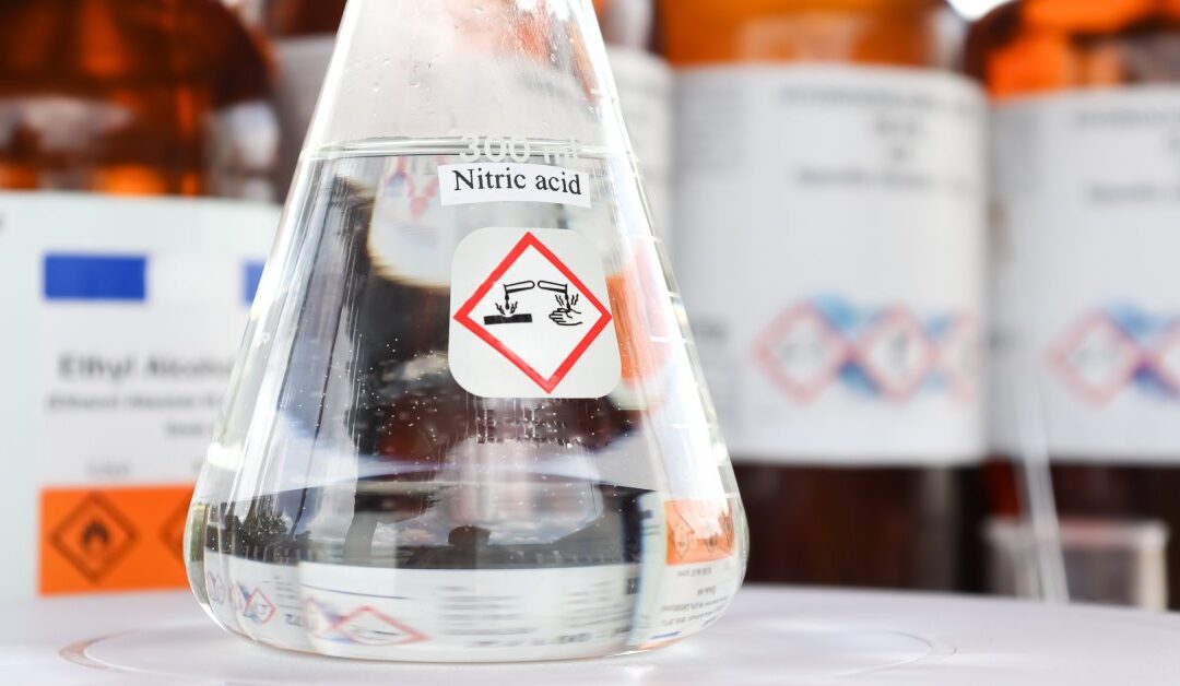 A laboratory glass with nitric acid inside of it. The glass has a nitric acid label on it and it's filled up to 300 ml.